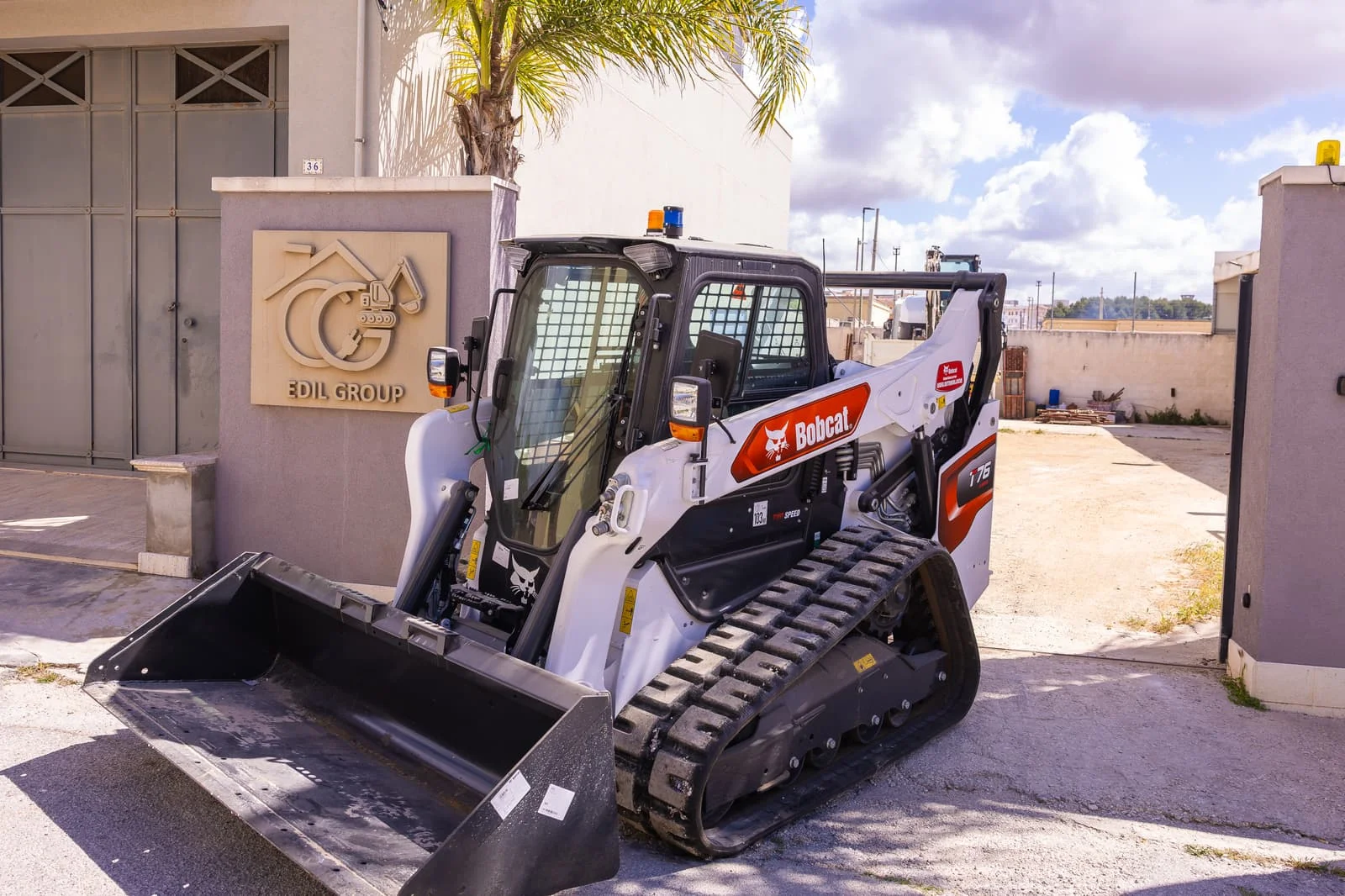 Mezzo cingolato Bobcat per scavo e movimento terra parcheggiato davanti alla sede dell'impresa edile Edil Group.